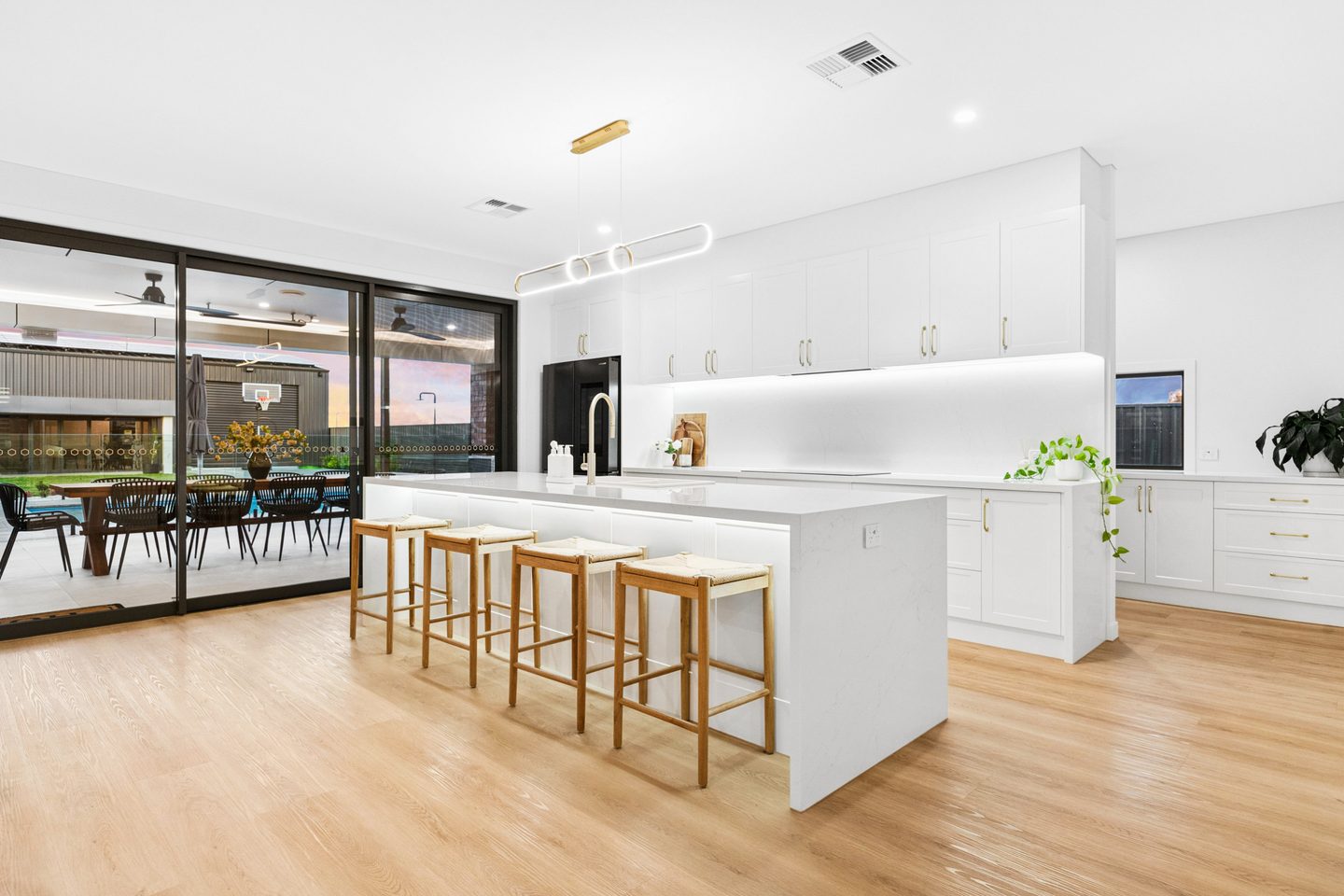 Waterfall-edge kitchen island beside sliding doors to the alfresco