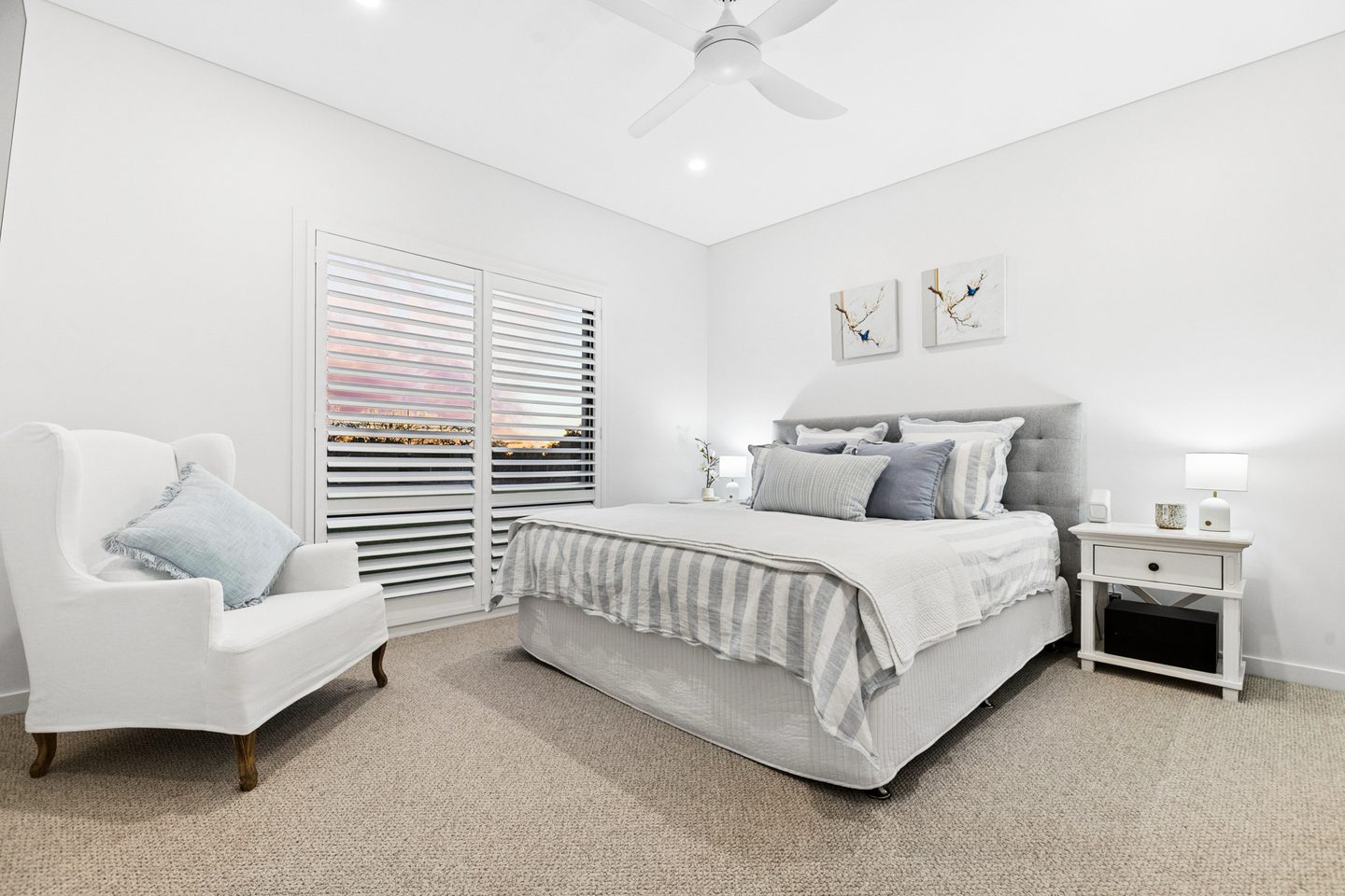 Main bedroom with shutters, carpet and ceiling fan