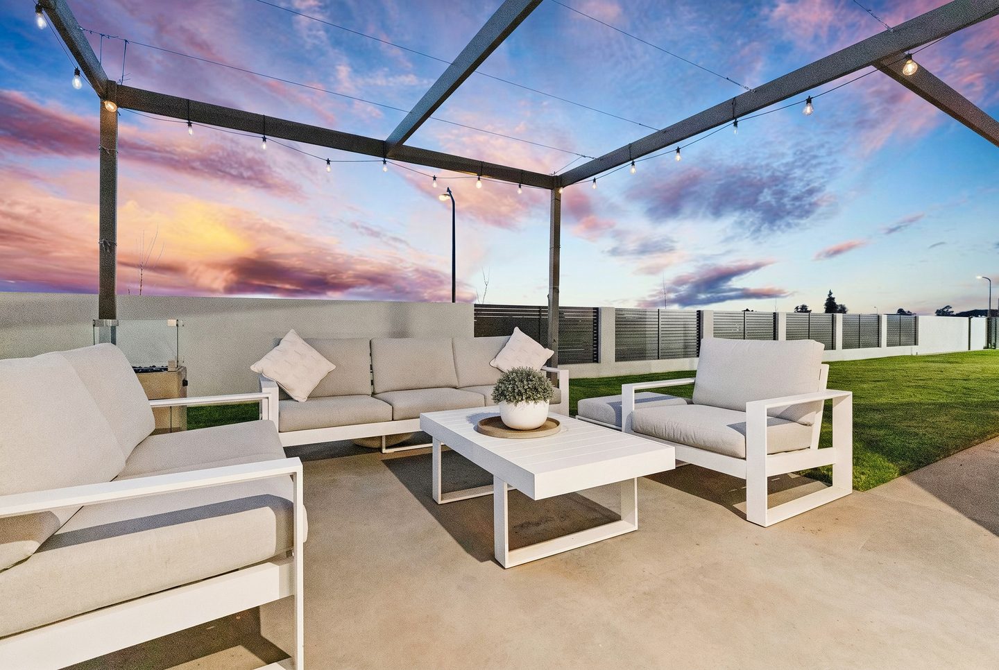 Garden terrace beneath an open pergola at twilight