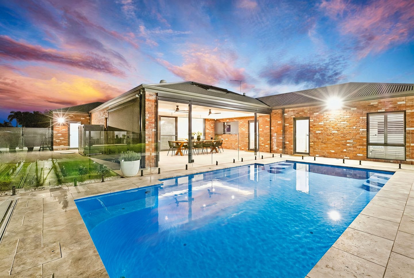 The pool and illuminated alfresco at 2 Largo Drive at dusk